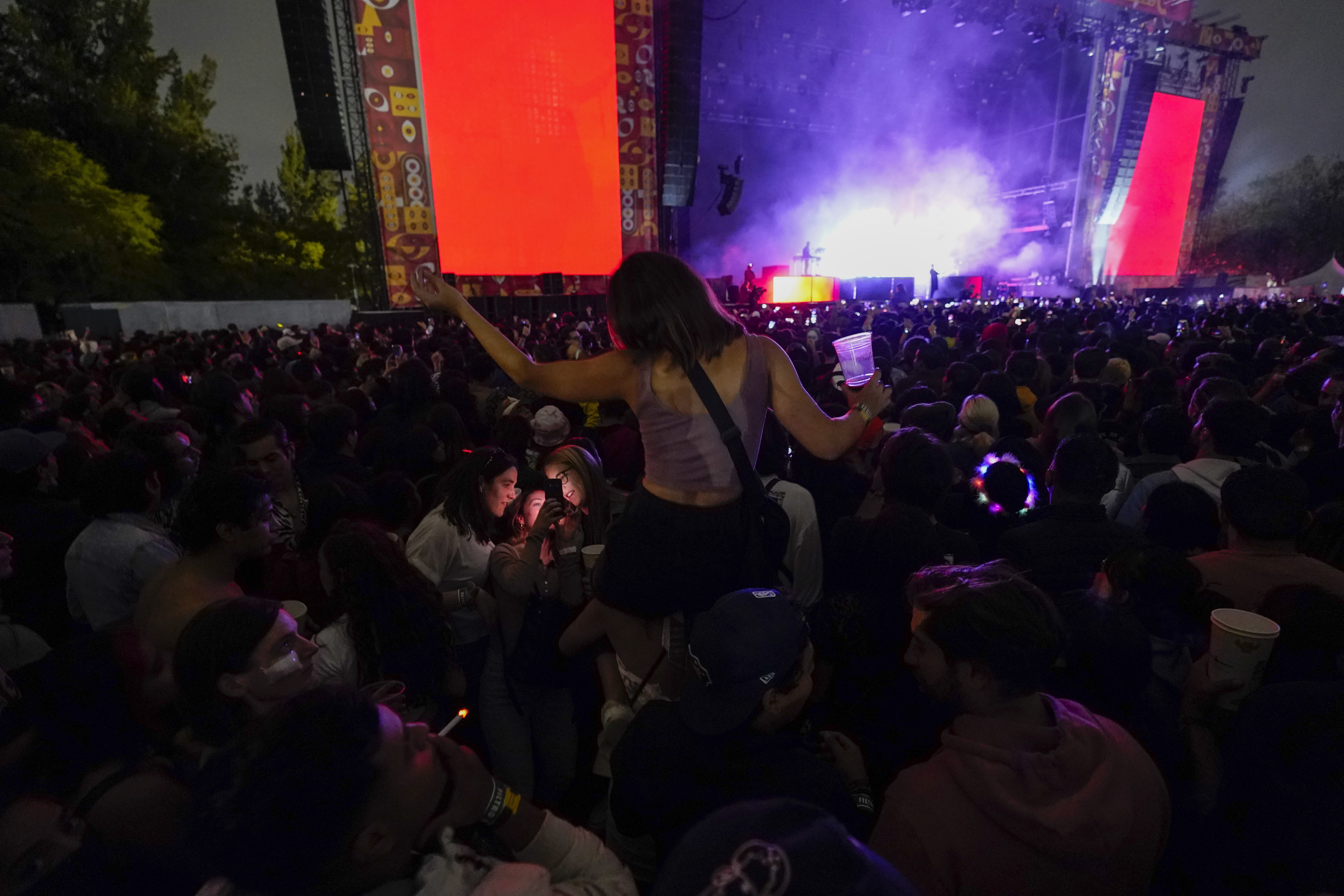 Fans of Tyrone Lindqvist, of the band Rufus Du Sol, watch him perform, during the Corona Capital music festival in Mexico City, Sunday, Nov. 21, 2021. Mexico City's first post-pandemic music festival took place this weekend. It's the first massive music festival with no capacity restrictions since 2020 following the relaxing of COVID-19 restrictions. (AP Photo/Eduardo Verdugo)