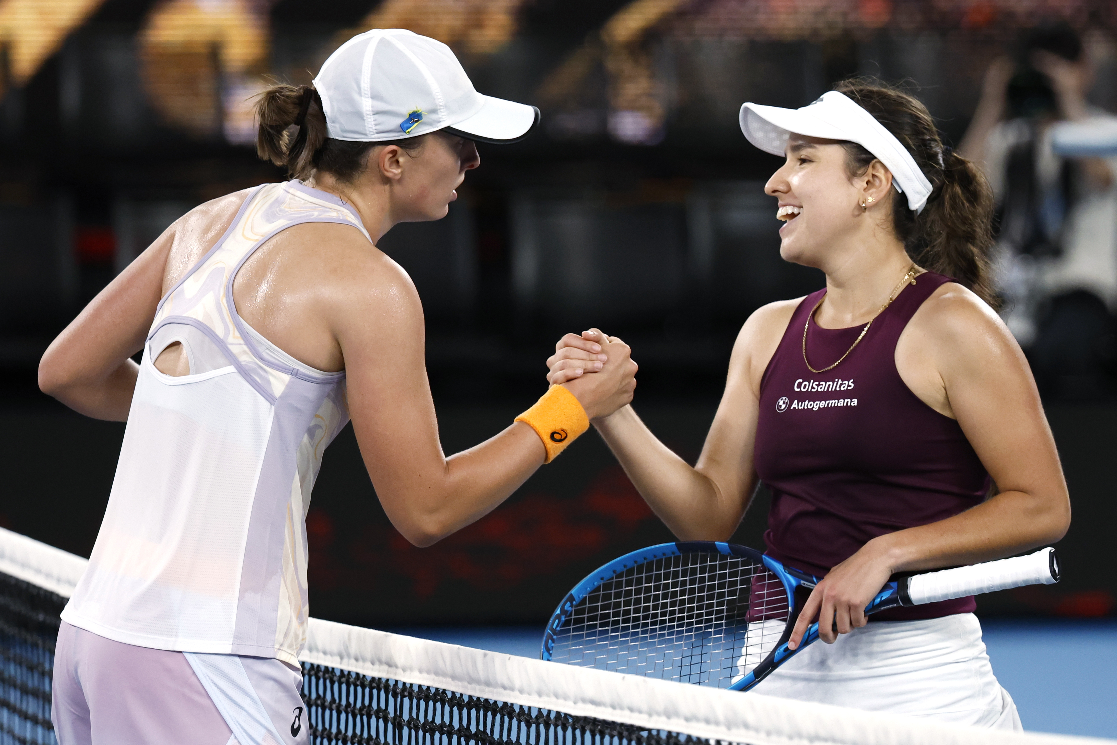 La polaca Iga Swiatek (izquierda) estrecha la mano de la colombiana Camila Osorio tras vencerla en el Abierto de Australia, el miércoles 18 de enero de 2023 (AP Foto/Asanka Brendon Ratnayake)