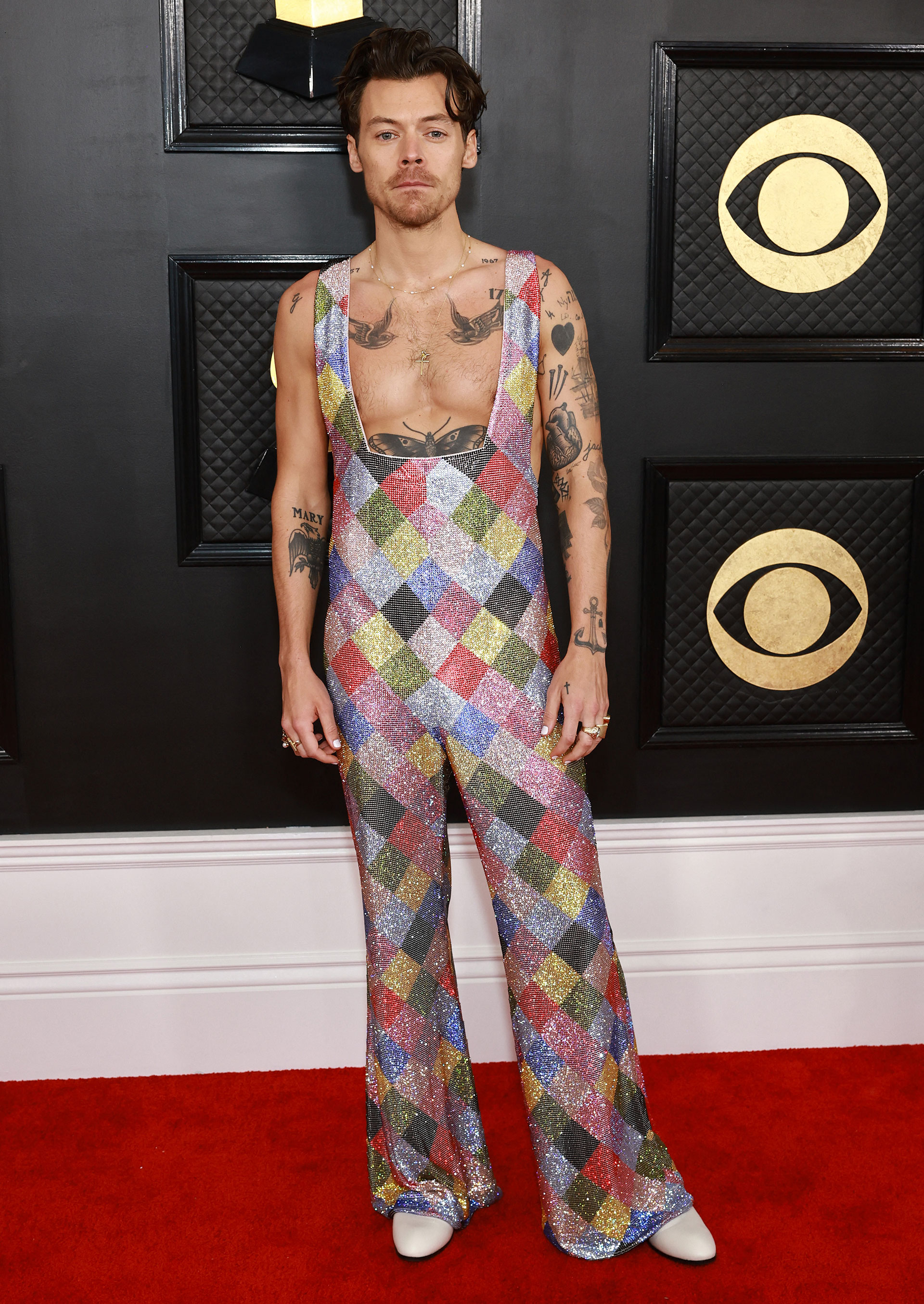 Harry Styles llegó a la alfombra roja con una única prenda de tirantes y piernas largas (AFP)