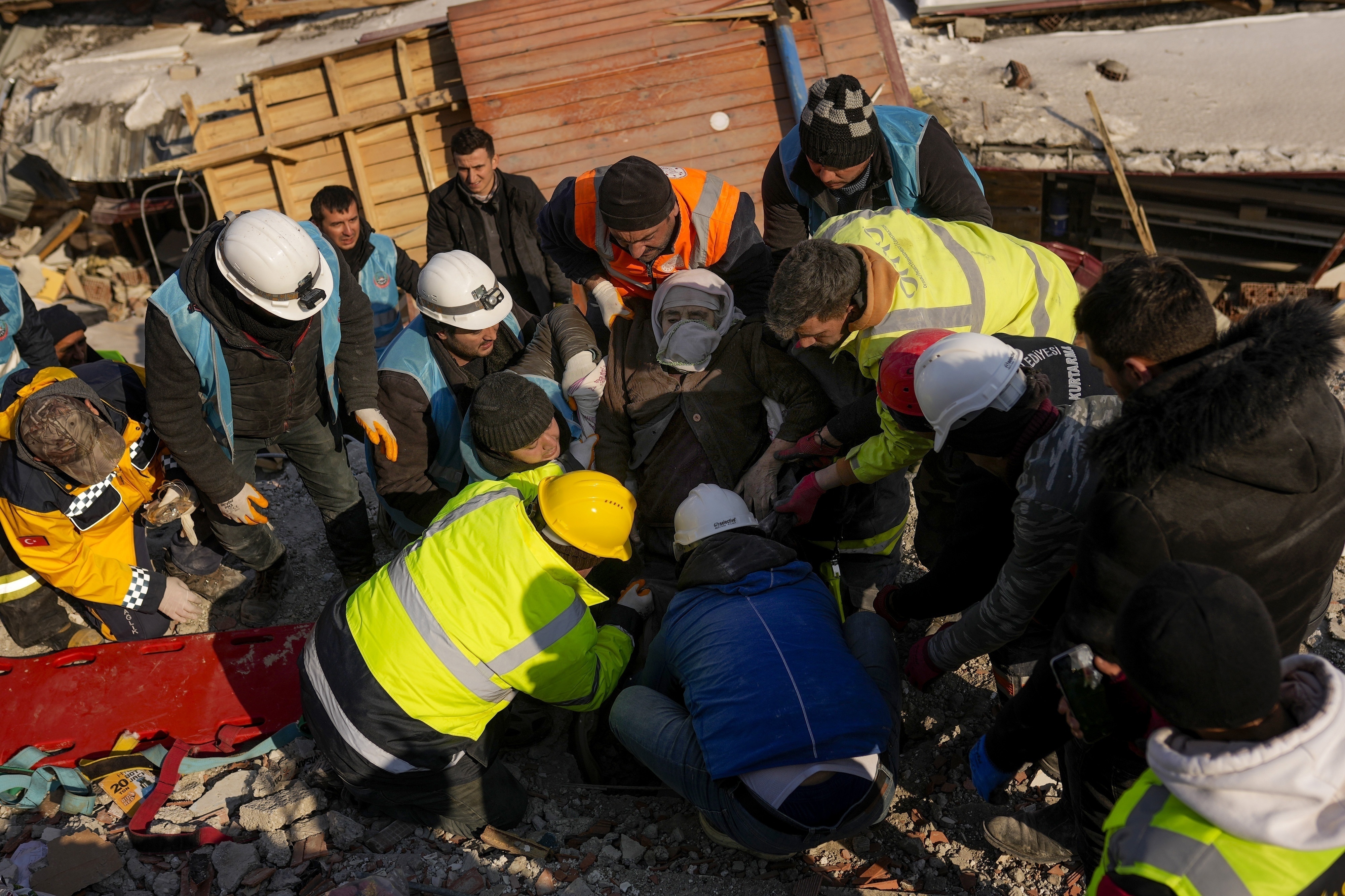 Hatice Korkut, una mujer de 82 años (centro), es rescatada con vida de entre los restos de un edificio derruido en Elbistan, en el sureste de Turquía, el 9 de febrero de 2023. (AP Foto/Francisco Seco)