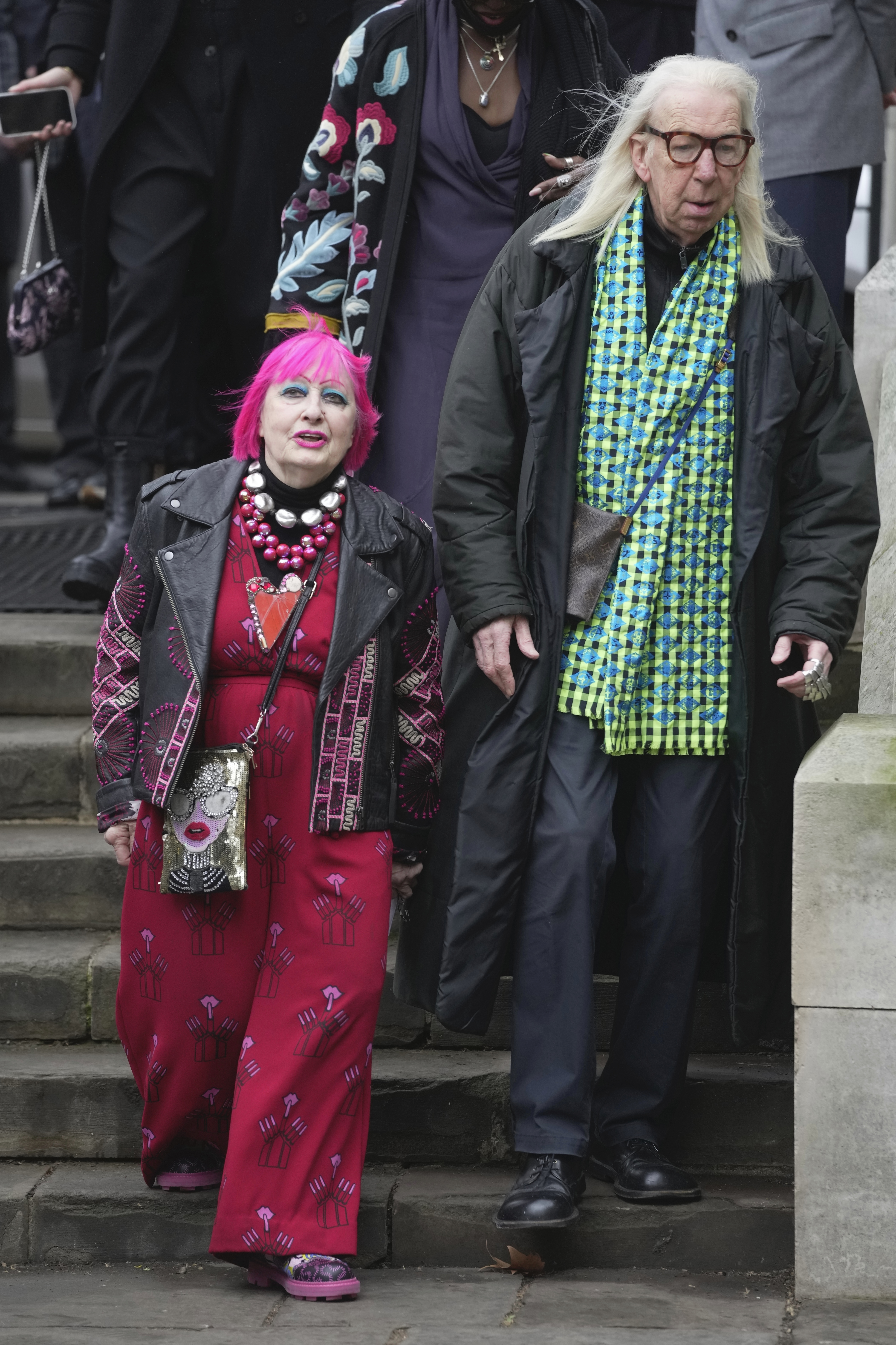 La diseñadora Zandra Rhodes, izquierda, llega a la misa conmemorativa para la fallecida diseñadora Vivienne Westwood en la Catedral de Southwark, en Londres, el jueves 16 de febrero de 2023. (Foto AP/Kin Cheung)