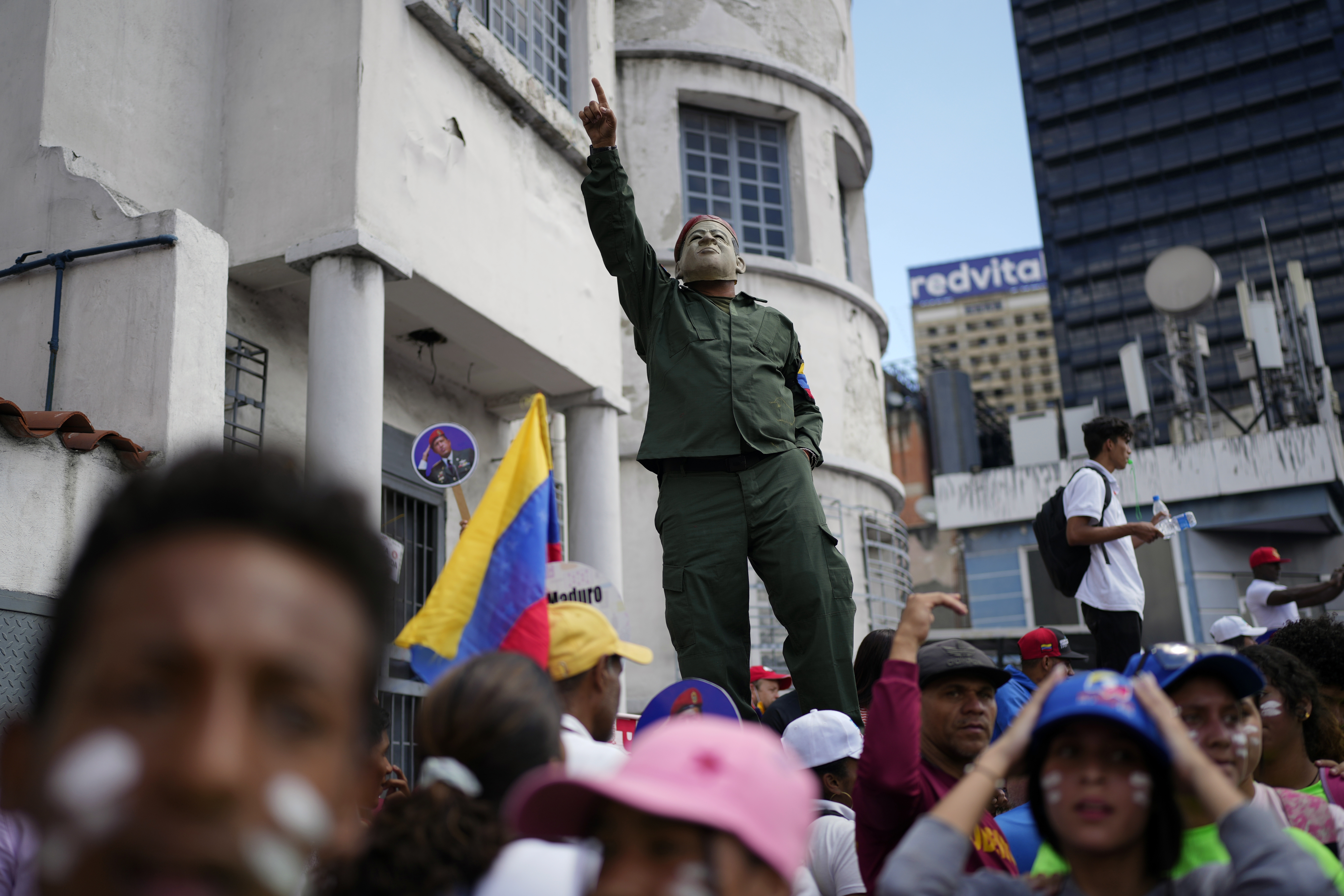 Un manifestante progubernamental, con una máscara con la imagen del fallecido presidente Hugo Chávez, durante una marcha por el Día de la Juventud, en Caracas, Venezuela, el 12 de febrero de 2023. El festejo anual conmemora a los jóvenes que acompañaron a los héroes en la batalla por la independencia del país. (AP Foto/Ariana Cubillos)