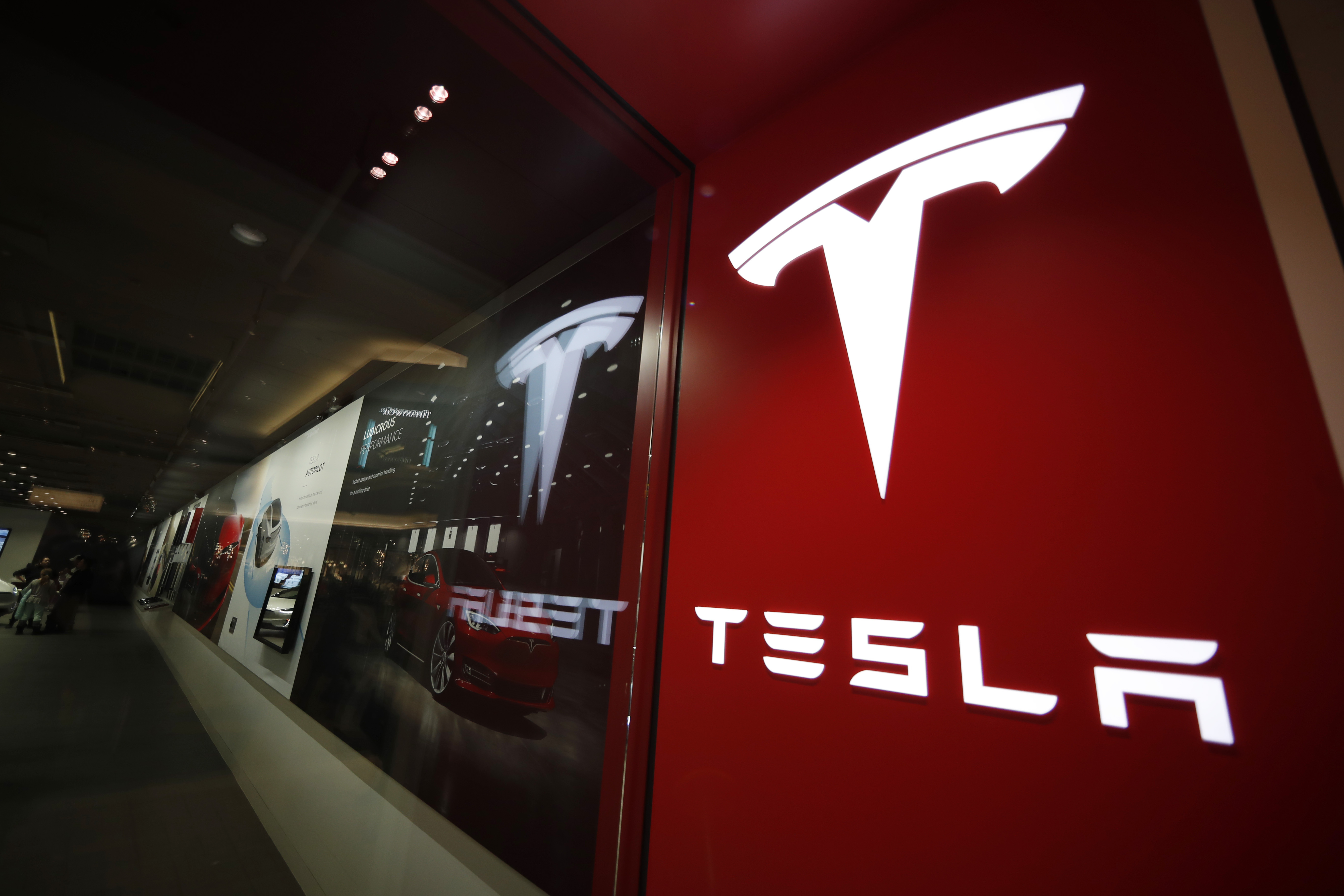 ARCHIVO - Un letrero con el logotipo de la empresa Tesla luce afuera de una tienda de estos vehículos eléctricos en el centro comercial Cherry Creek, el 9 de febrero de 2019, en Denver, Colorado. (AP Foto/David Zalubowski, archivo)