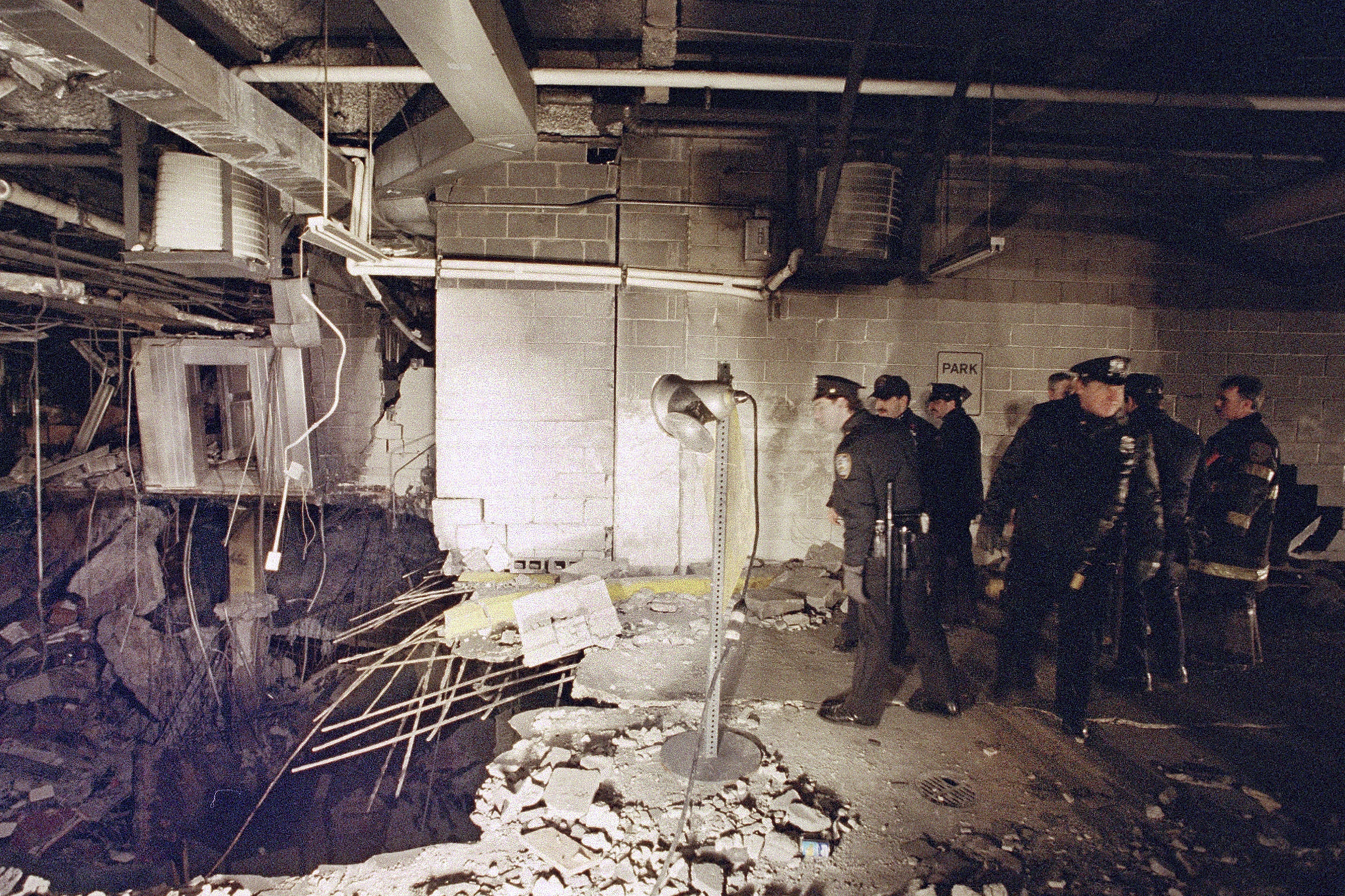 ARCHIVO - Policías y bomberos inspeccionan el cráter generado por una bomba en un estacionamiento subterráneo del Centro Mundial de Comercio en Nueva York, el 27 de febrero de 1993, un día después de la explosión. (AP Foto/Richard Drew, archivo)