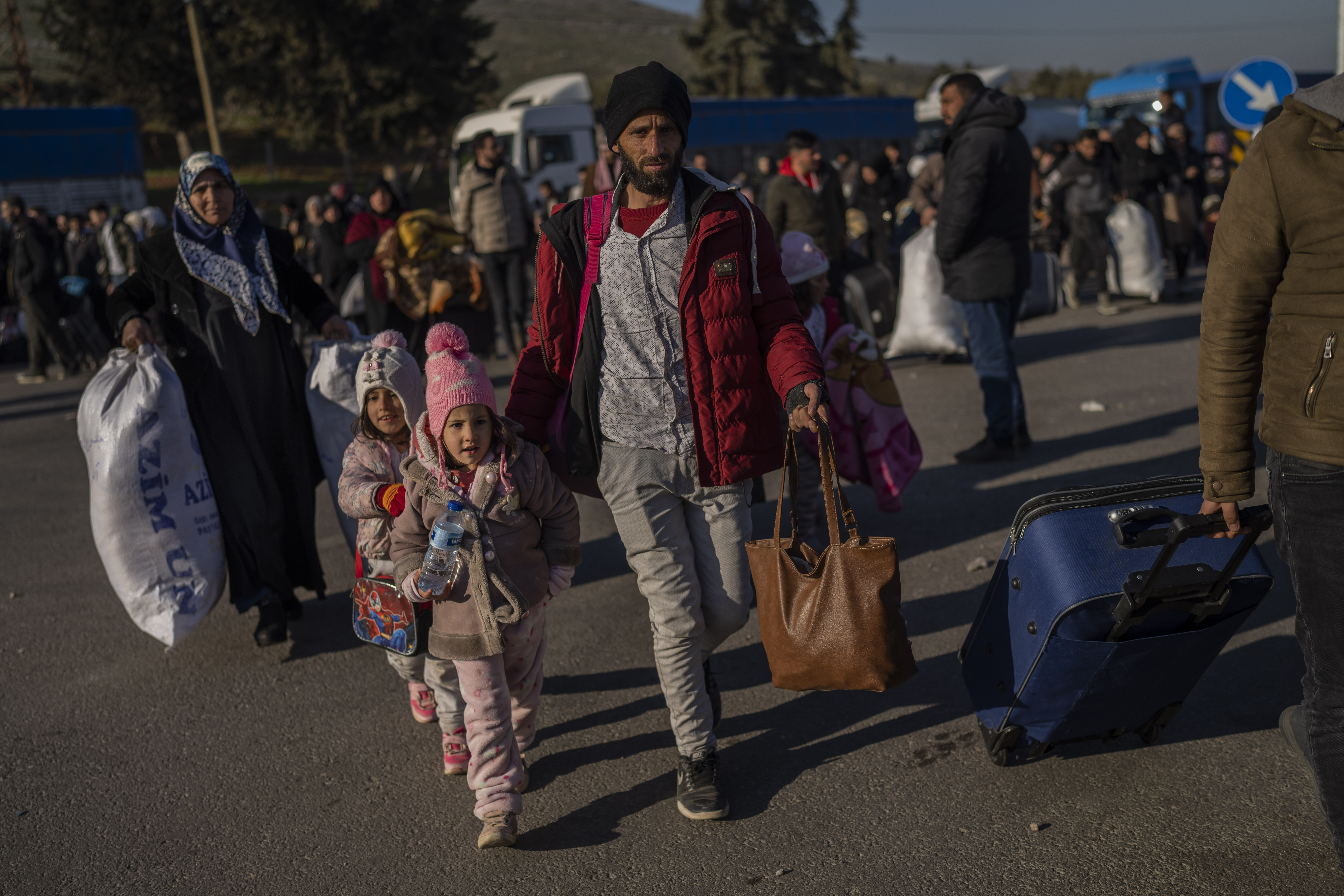 Sirios ingresan a su país desde el punto de cruce turco de Cilvegozu, en Reyhanli, sureste de Turquía, el sábado 18 de febrero de 2023, casi dos semanas después del fatal sismo. (Foto AP/Bernat Armangue)