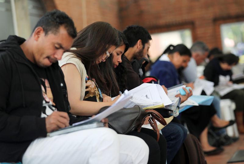 Foto de archivo. Personas llenan sus solicitudes de empleo mientras buscan oportunidades de trabajo en Bogotá, Colombia. REUTERS/Luisa González