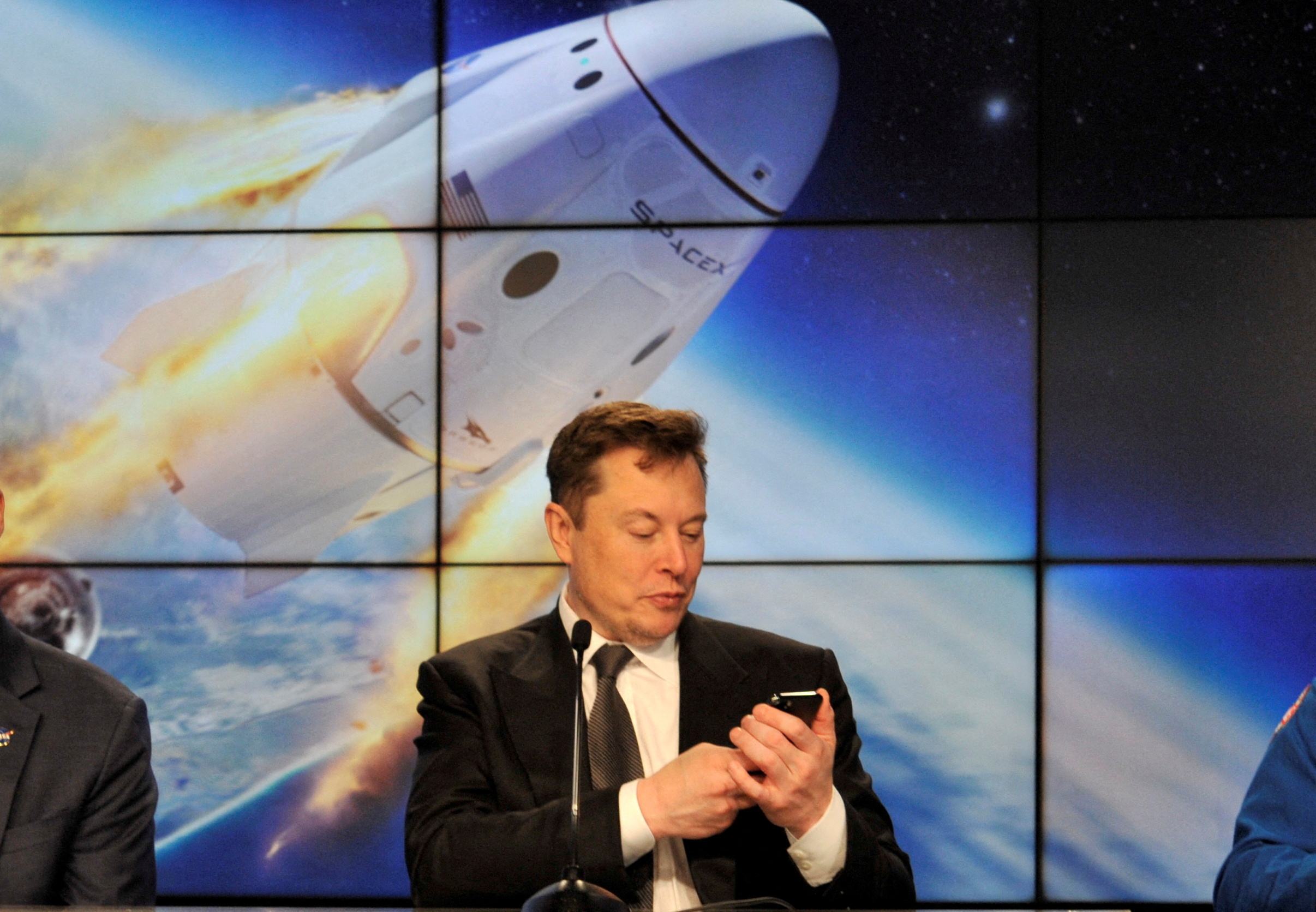 FILE PHOTO: Elon Musk looks at his mobile phone at the Kennedy Space Center in Cape Canaveral, Florida, U.S. January 19, 2020. REUTERS/Steve Nesius/File Photo