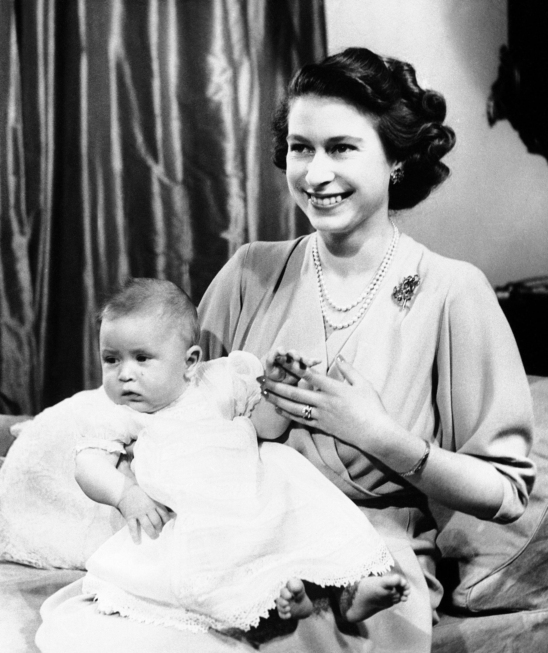 En esta foto de archivo del 10 de abril de 1949, el Príncipe Carlos de Edimburgo, a la izquierda, se sienta para una foto con su madre, la Princesa Isabel, en el Palacio de Buckingham, Londres (AP)