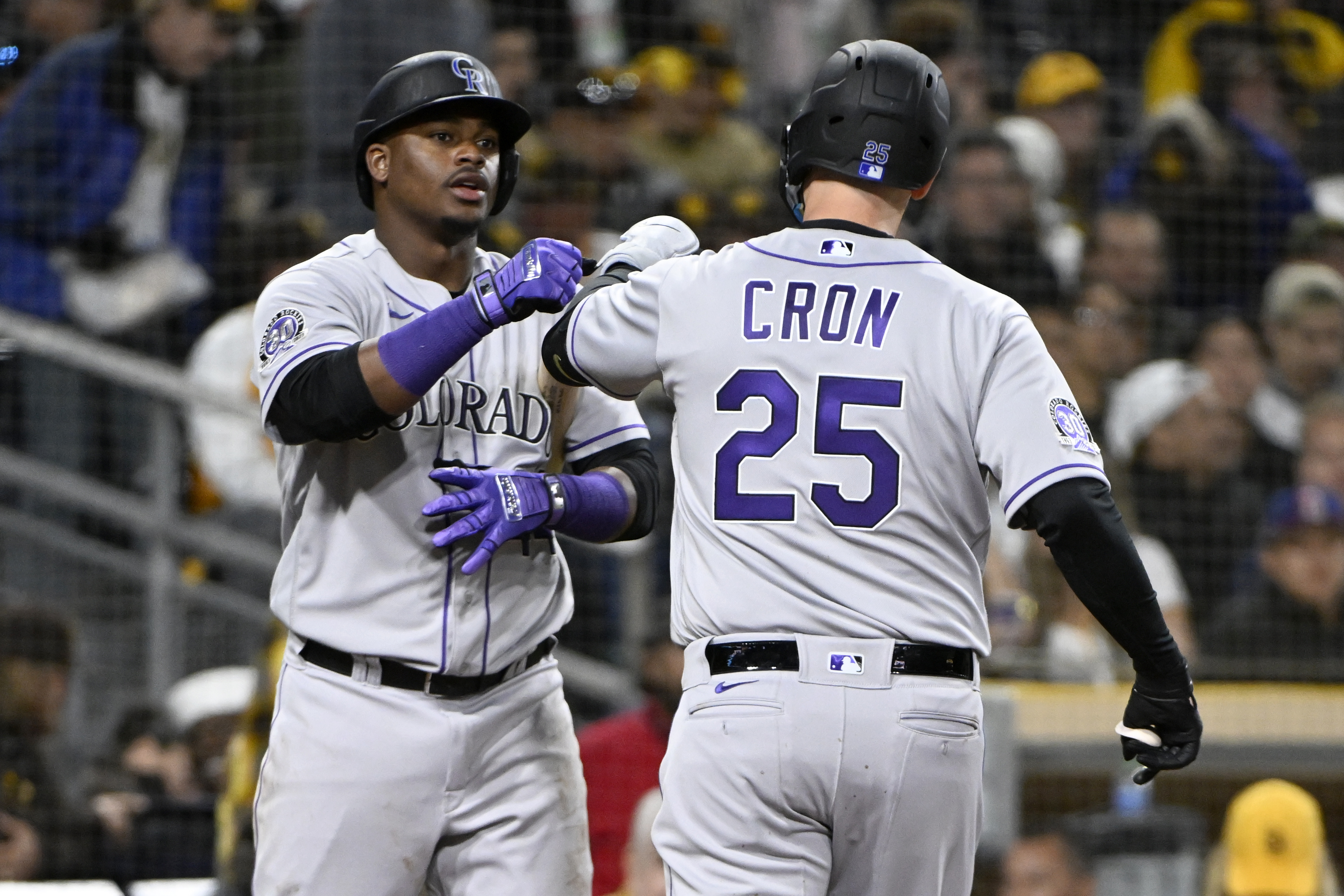 C.J. Cron, de los Rockies de Colorado, es felicitado por su compañero, el dominicano Elehuris Montero, luego de batear un jonrón ante los Padres de San Diego, el jueves 30 de marzo de 2023 (AP Foto/Alex Gallardo)