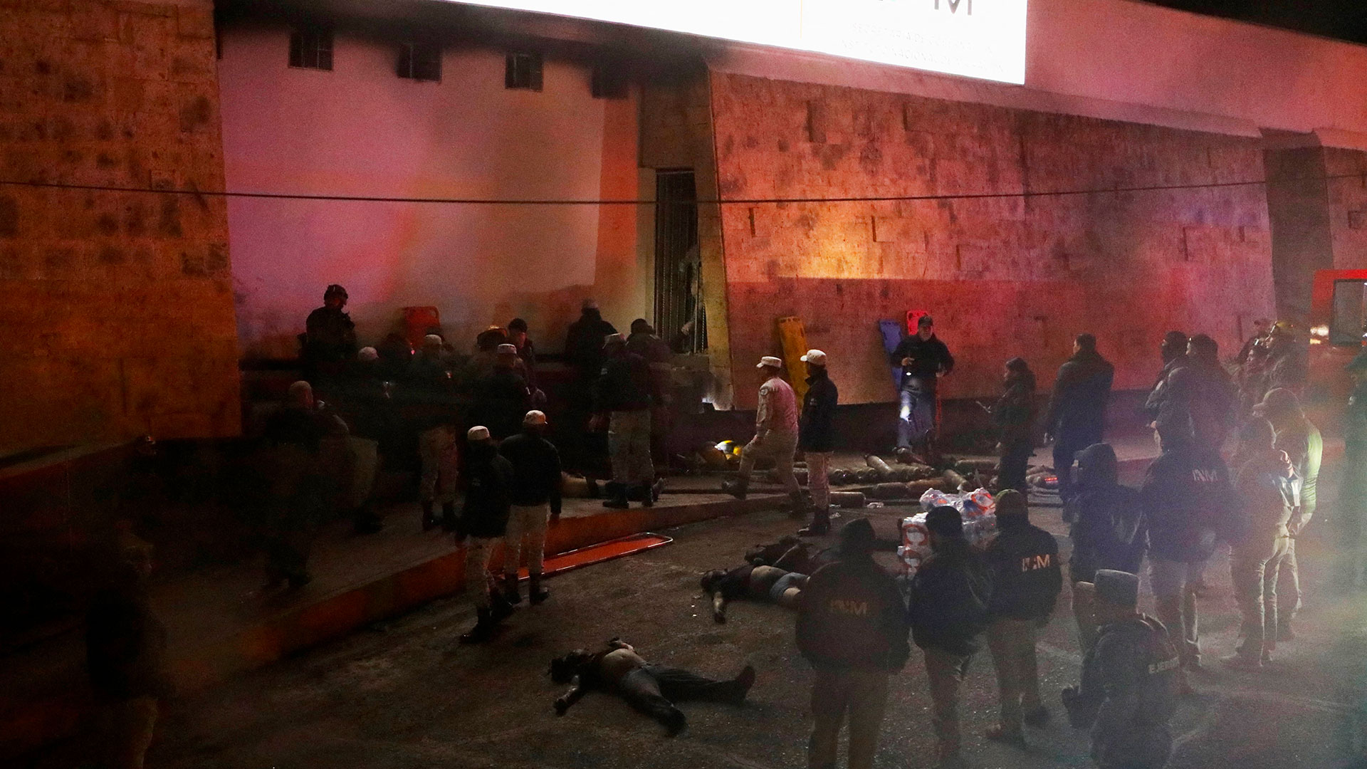 TOPSHOT - Firefighters and police rescue migrants from an immigration station in Ciudad Juarez, Chihuahua state on March 27, 2023, where at least 39 people were killed and dozens injured after a fire at the immigration station. (Photo by HERIKA MARTINEZ / AFP)