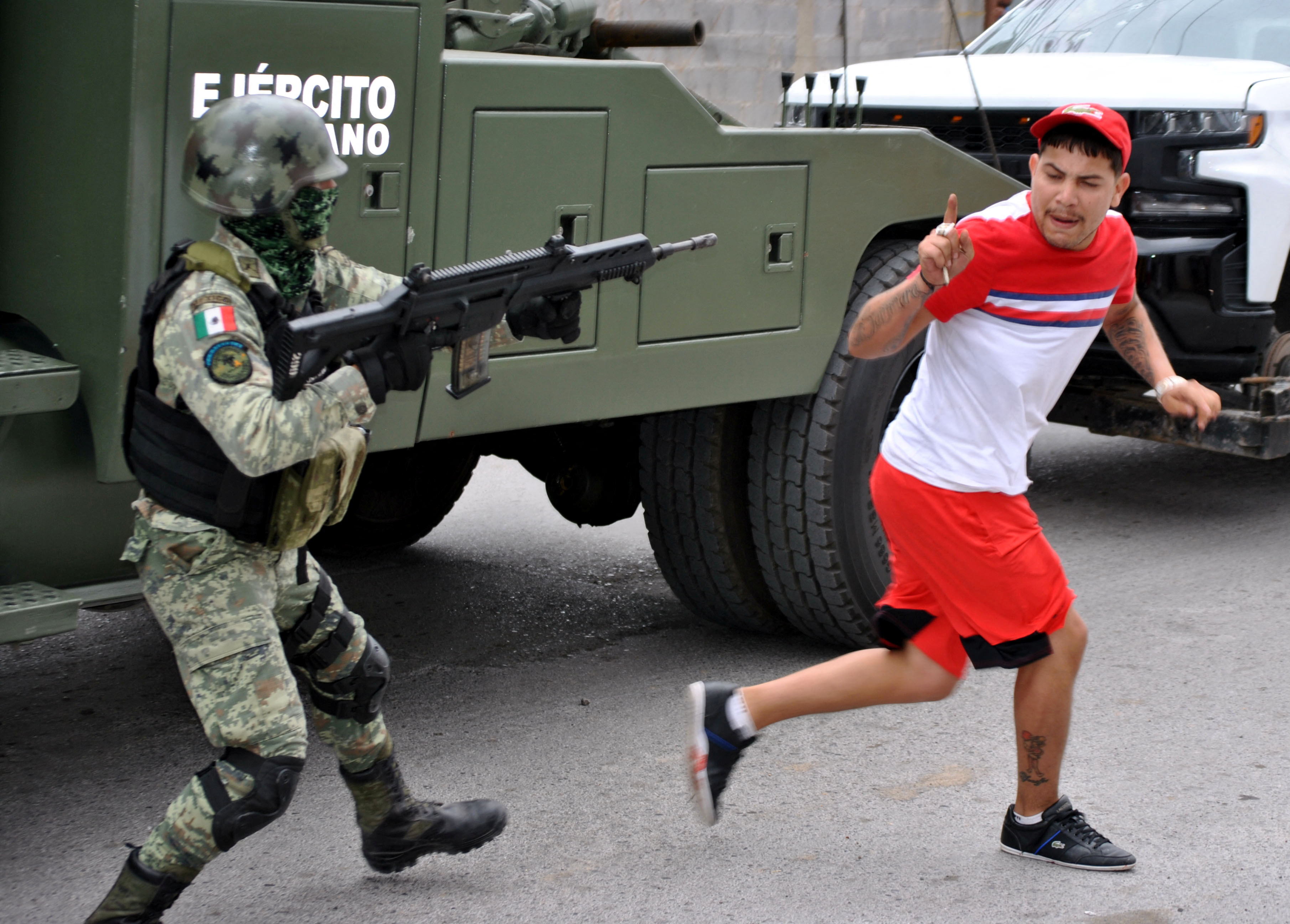 A Mexican soldier points his rifle at a man, who had accused the soldier of having participated with other military members in the shooting deaths of five people, in Nuevo Laredo, Mexico February 26, 2023. REUTERS/Jasiel Rubio NO RESALES. NO ARCHIVES