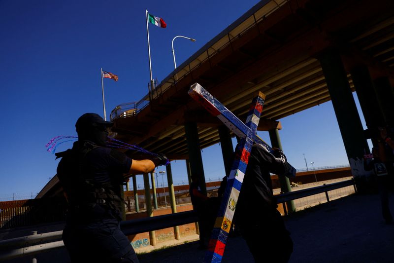 Yilber Zavaleta, un migrante de Venezuela, lleva una cruz para recrear la crucifixión de Jesucristo como parte de una protesta después de que estalló un incendio en un centro de detención de migrantes, a lo largo del río Bravo en la frontera entre México y Estados Unidos, en Ciudad Juárez, México.