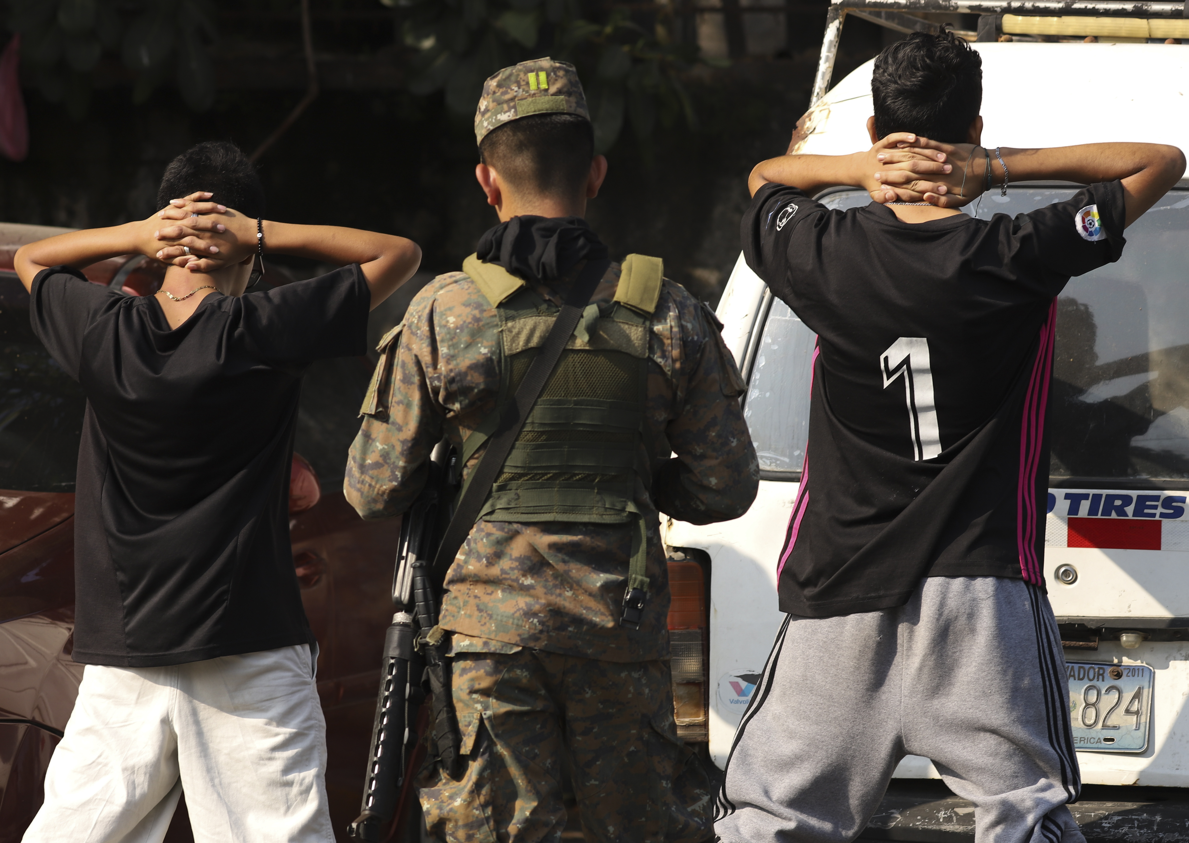 Un militar comprueba la identidad de dos jóvenes en plena calle en el barrio de La Campanera en Soyapango, El Salvador, el domingo 5 de marzo de 2023 (AP Foto/Salvador Melendez)