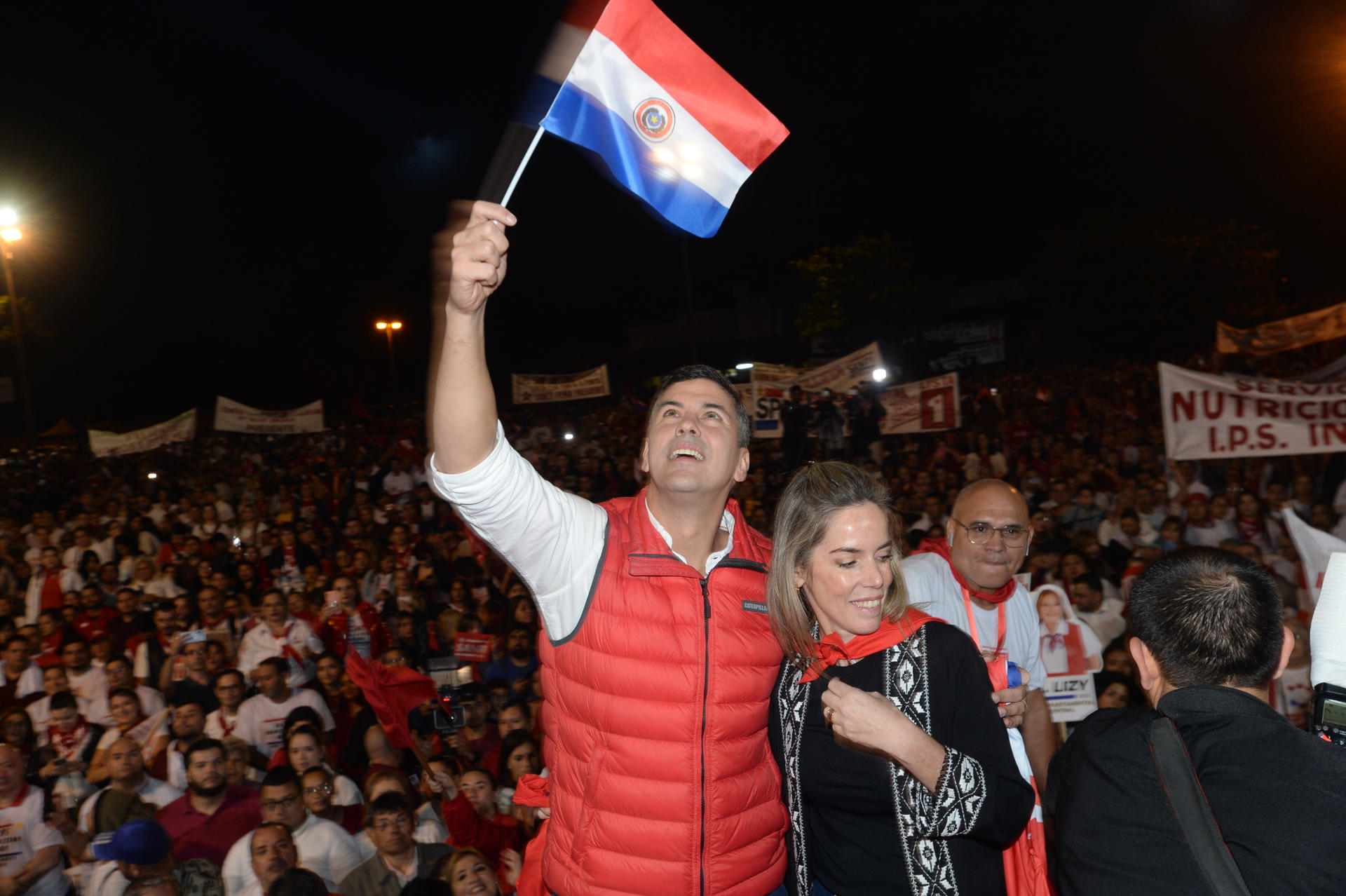 El candidato a la Presidencia de Paraguay por el Partido Colorado oficialista Santiago Peña Palacios y su esposa Leticia Ocampos saludan a cientos de simpatizantes durante el acto de cierre de su campaña, en la ciudad de Asunción (EFE/Daniel Piris)