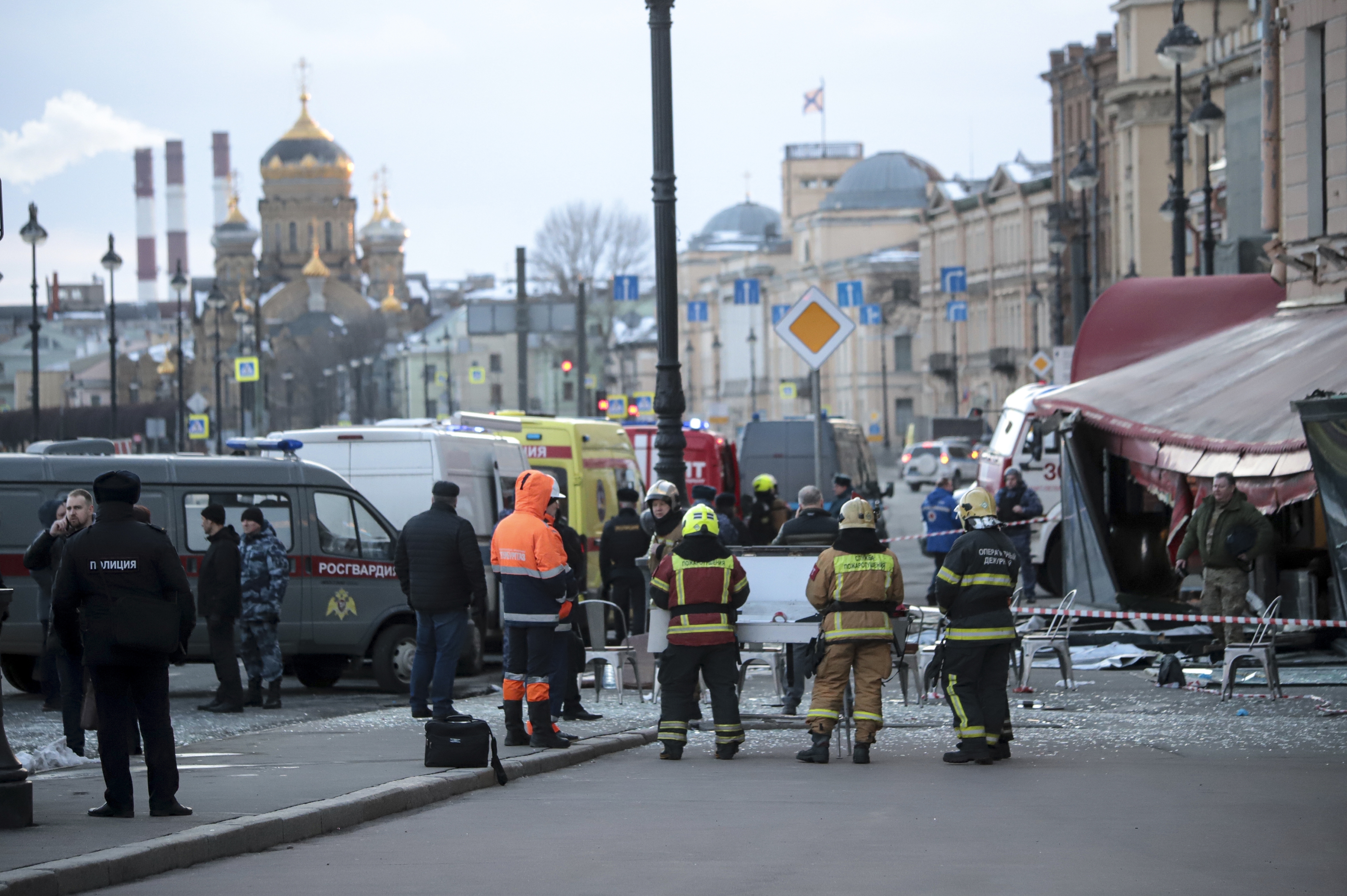 Miembros del Ministerio ruso de Emergencias de pie en el lugar de una explosión en una cafetería de San Petersburgo, Rusia, el domingo 2 de abril de 2023. La policía rusa buscaba el lunes a una mujer sospechosa de haber llevado la bomba que mató a un conocido bloguero militar que apoyaba con fervor la guerra en Ucrania. (AP Foto)