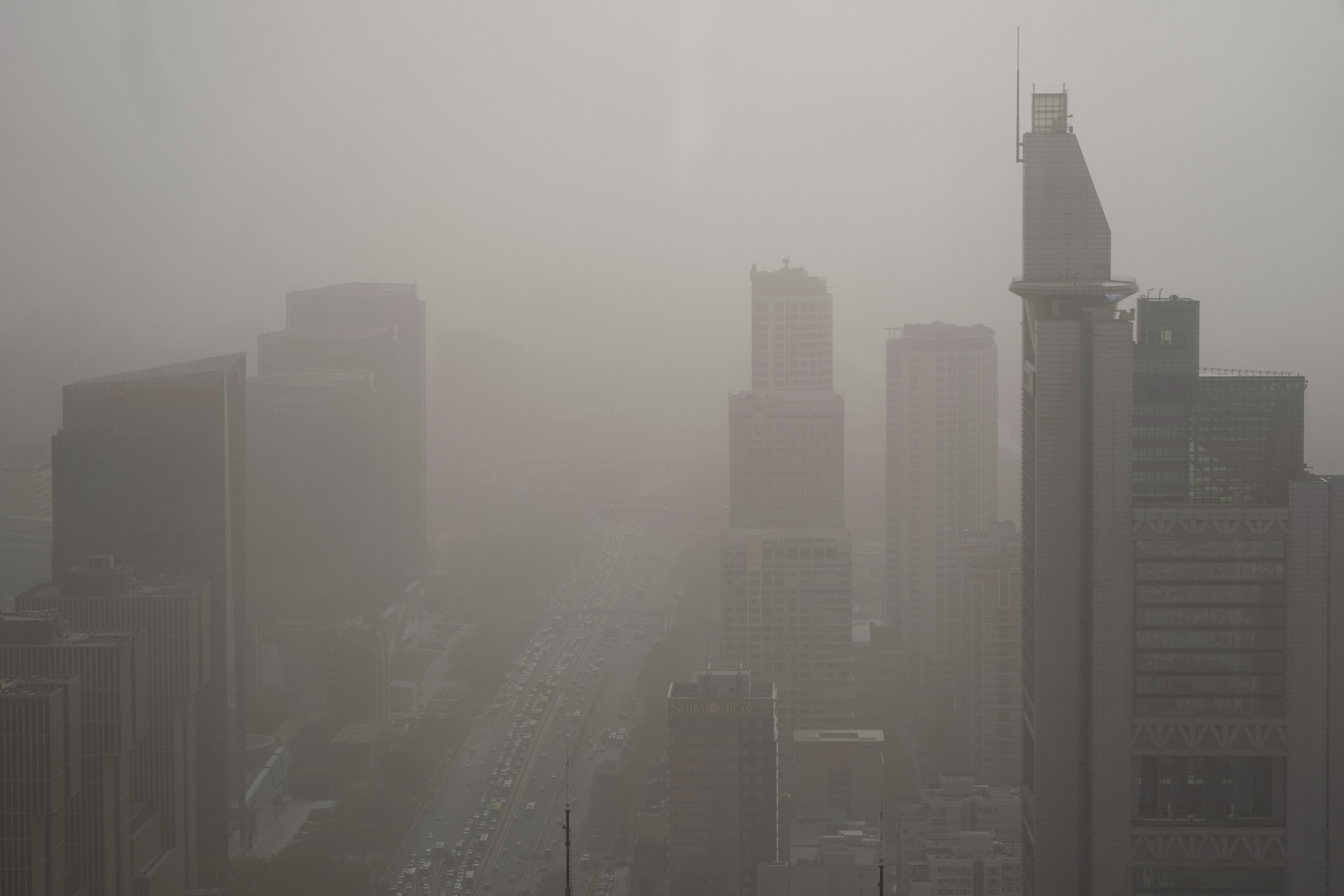Edificios envueltos en una nube de polvo y arena en Beijing, el 11 de abril de 2023. (AP Foto/Mark Schiefelbein)