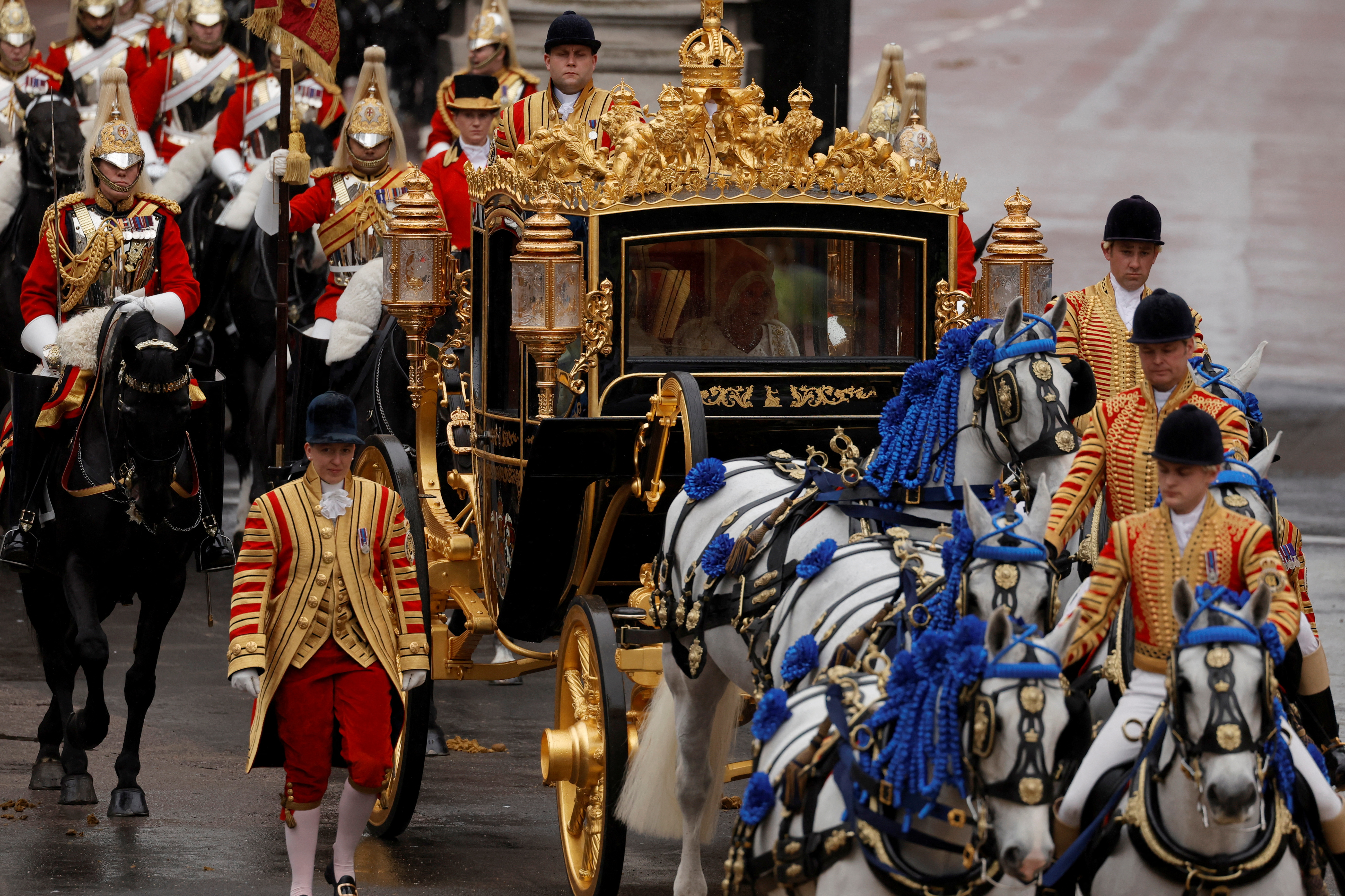 El rey Carlos de Inglaterra y la reina Camilla viajan en el autobús de Estado del Jubileo de Diamante pasando por el Arco del Almirantazgo desde el Palacio de Buckingham hasta la Abadía de Westminster para su ceremonia de coronación a lo largo de Whitehall en Londres, Gran Bretaña, el 6 de mayo de 2023. REUTERS/Piroschka van de Wouw/Pool
