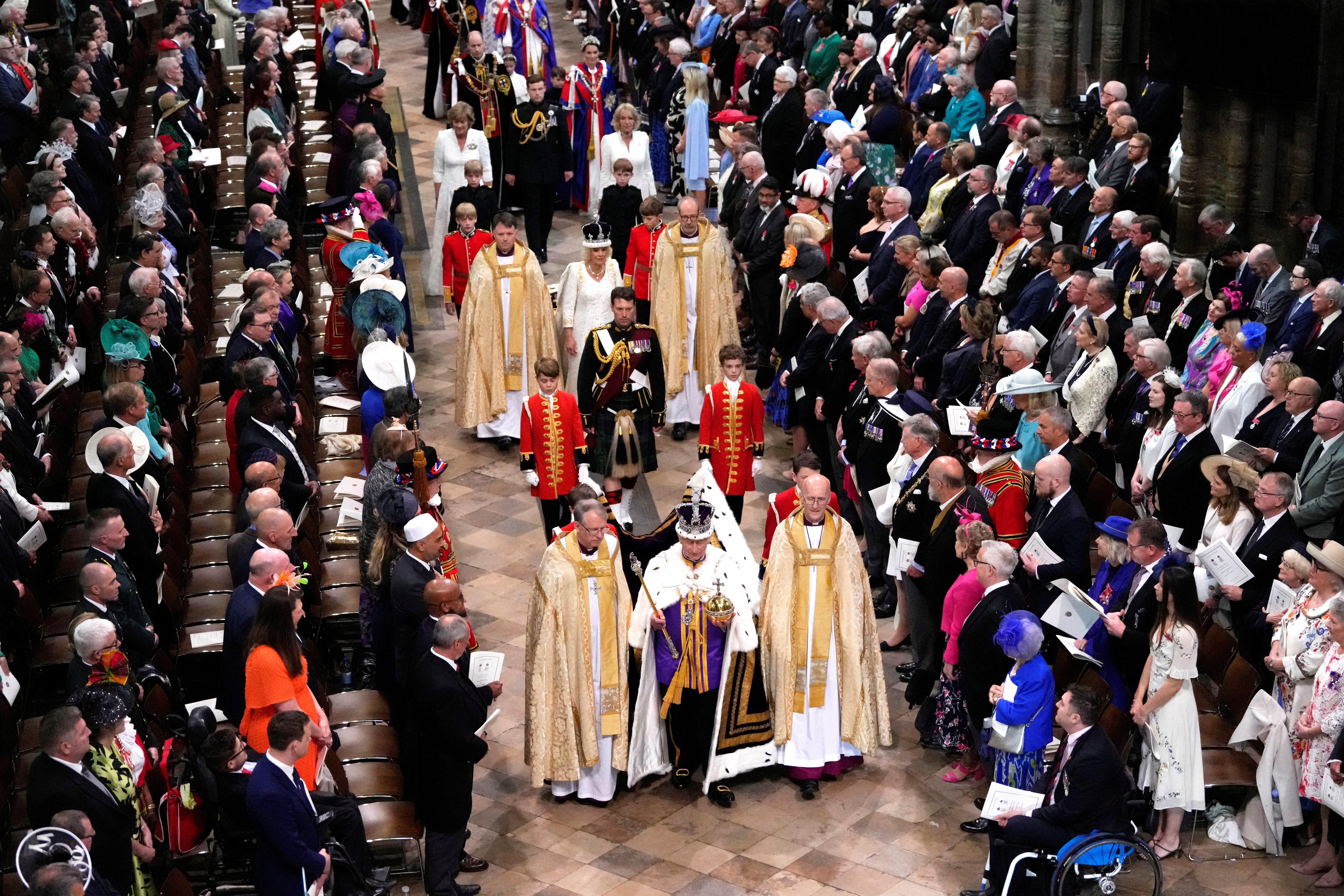 El rey Carlos III de Gran Bretaña, delante en el centro, y la reina Camilla, en el centro, caminan en la Procesión de la Coronación en la Abadía de Westminster en Londres el sábado 6 de mayo de 2023. Kirsty Wigglesworth/Pool vía REUTERS