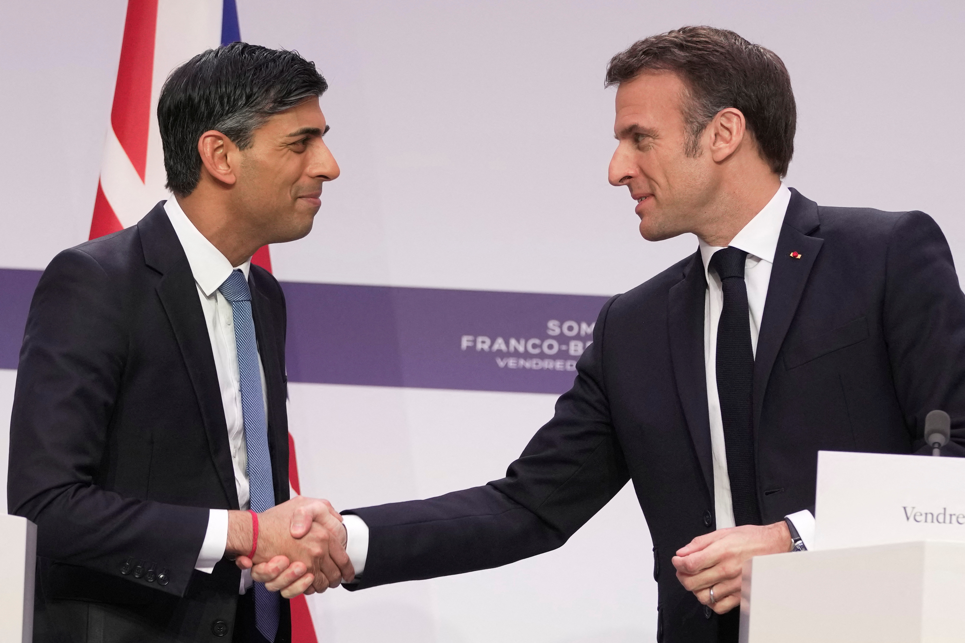 El presidente francés Emmanuel Macron y el primer ministro británico Rishi Sunak se dan la mano. Kin Cheung/Piscina vía REUTERS