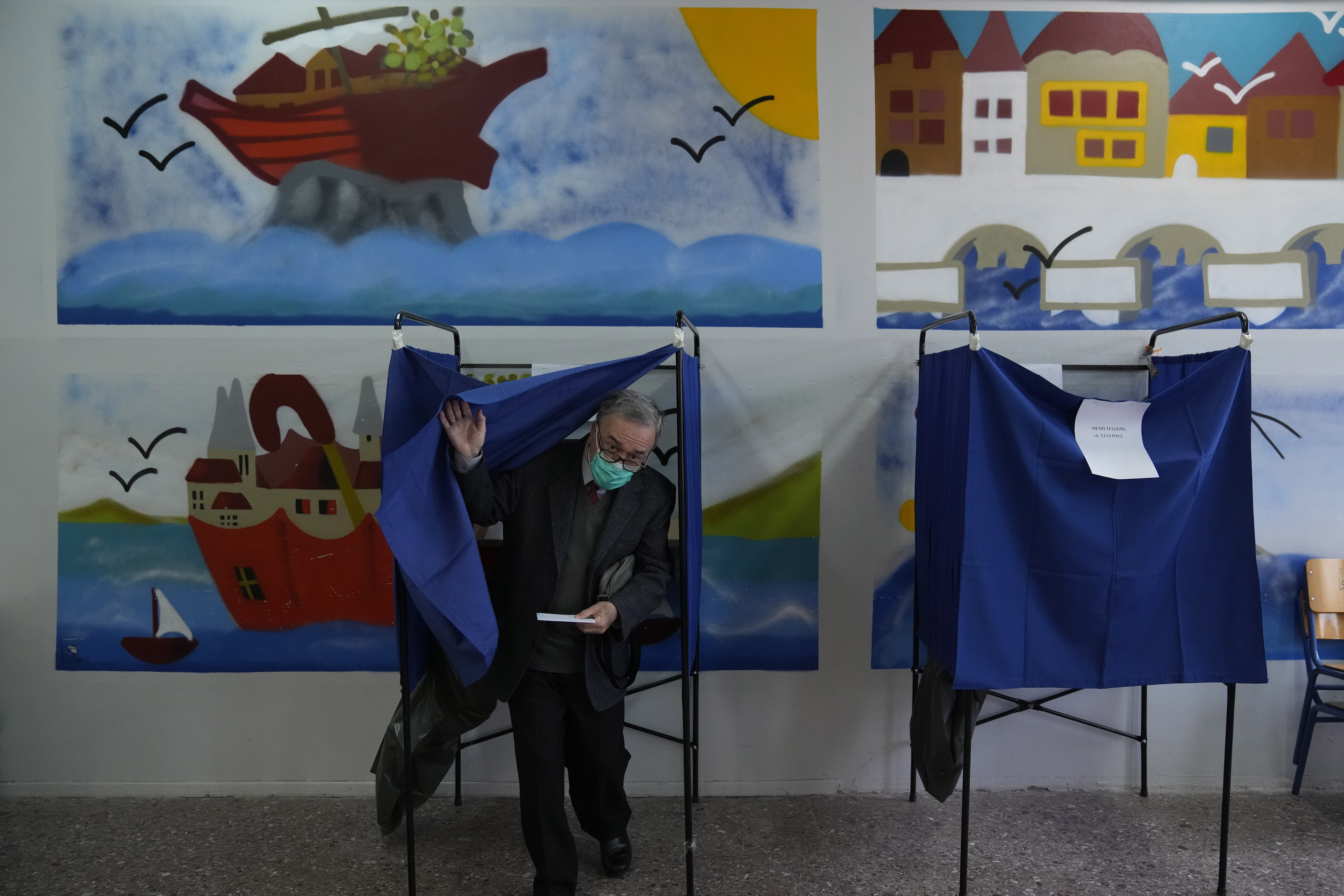 Un hombre sale de la cabina de votación antes de votar en Atenas, Grecia, el domingo 21 de mayo de 2023. Los griegos votaban el domingo en las primeras elecciones desde que la economía de su país dejó de estar sujeta a la estricta supervisión y control de prestamistas internacionales que costearon el rescate del país durante casi una década de crisis financiera. (AP Foto/Thanassis Stavrakis)