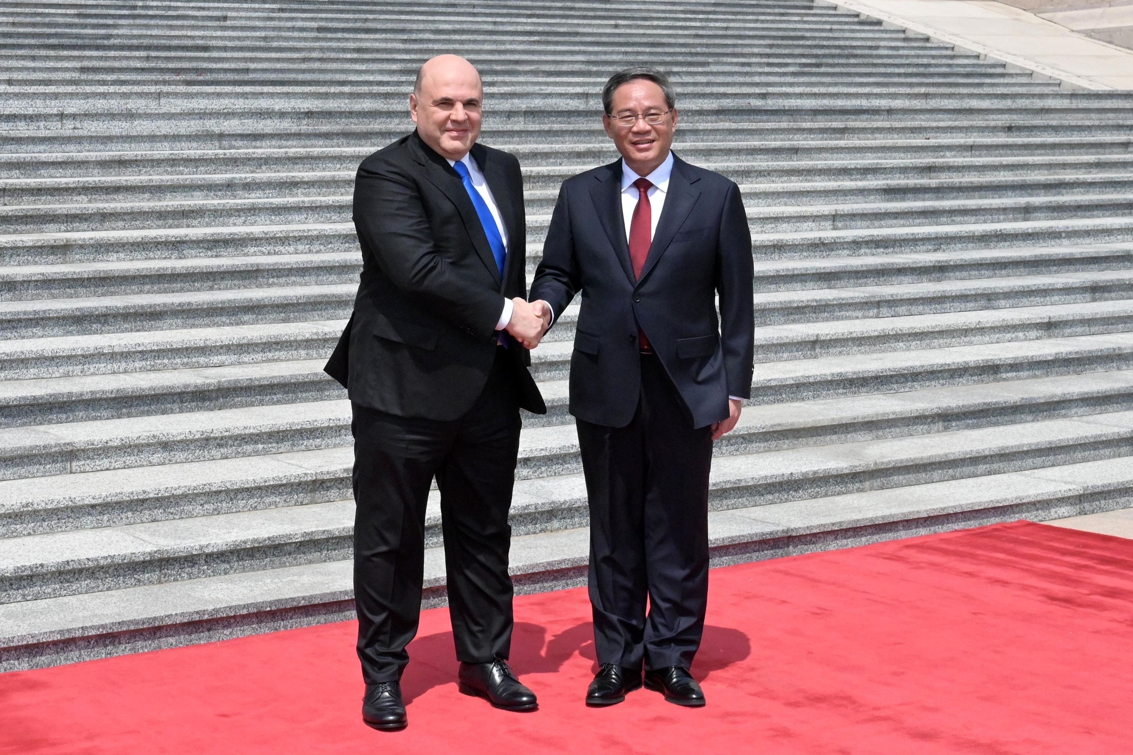 El primer ministro ruso, Mikhail Mishustin, a la izquierda, y el primer ministro chino, Li Qiang, asisten a una ceremonia de bienvenida en Beijing, China, el miércoles 24 de mayo de 2023. (Alexander Astafyev, Sputnik, imagen del pool del gobierno via AP)